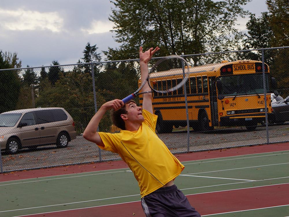 Junior+Andrew+Szot+strikes+a+quick+pose+before+he+serves+the+ball+in+his+tennis+match