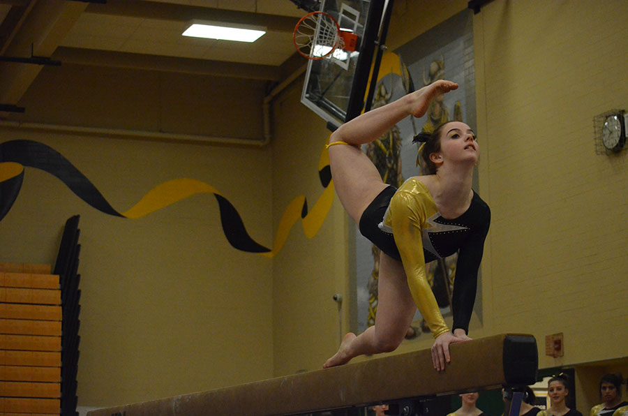 Junior+Charlotte+Berkman+focuses+on+her+balance+during+her+beam+routine.