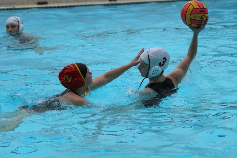 Junior+Maddie+Kutzera%2C+against+a+Newport+High+School+player%2C+defends+the+ball+as+she+searches+the+pool+for+a+team+member+who+would+receive+the+pass.