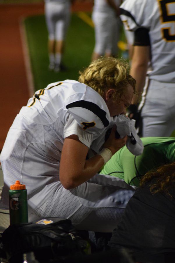 Senior quarterback Brayden Mills sits on the sideline after breaking his fibula and dislocating his ankle during the Vikings game at Lake Washington on Sept. 9. The team has had many injuries this season and hopes that they can succeed despite these setbacks. Inglemoor went on to lose the game 31-21. 