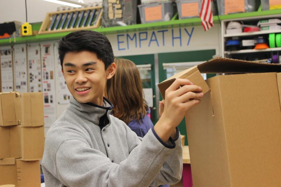 Junior Eric Ni folds his stool, Mace, together. His team said they were aiming for a simplistic yet modern design.