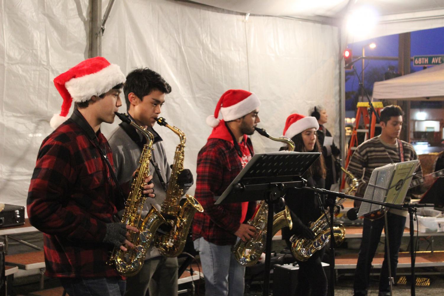 Students+play+Deck+the+Halls+at+the+Kenmore+Christmas+Tree+Lighting+no+Dec.+2.+Musicians+%28from+left+to+right%29%3A+Ethan+Pickering%2C+Eric+Ni%2C+Naz+Astudillo+and+Melia+Baquian+on+the+saxophone+and+Beto+Palma+on+the+guitar.+Though+the+weather+was+rainy%2C+the+musicians+played+music+throughout+the+event%2C+raising+money+for+the+American+Cancer+Society.