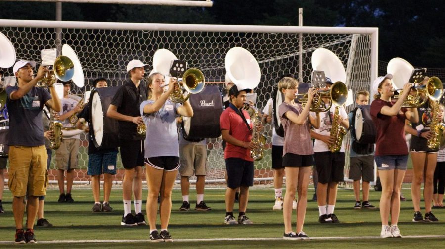 In the front row, senior Berk Uzuncaova plays mellophone and senior Hannah Wiggins, freshman Holland Stuart and junior Chloe Person play baritone during a practice runthrough of the Inglemoor Fight Song, a favorite amongst students at football games.