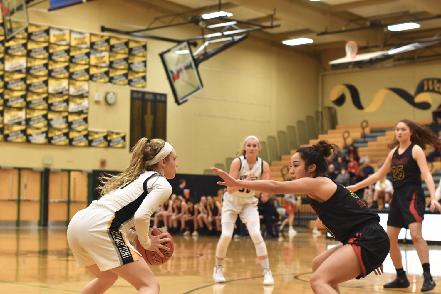 Junior+Lucy+Young+faces+a+Newport+defender+as+she+scans+the+court+for+an+open+teammate.+The+team+would+go+on+to+win+with+a+score+of+57-48.+