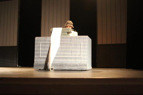 Naima Scharl, playing the role of one of the witches, types away on her typewriter.