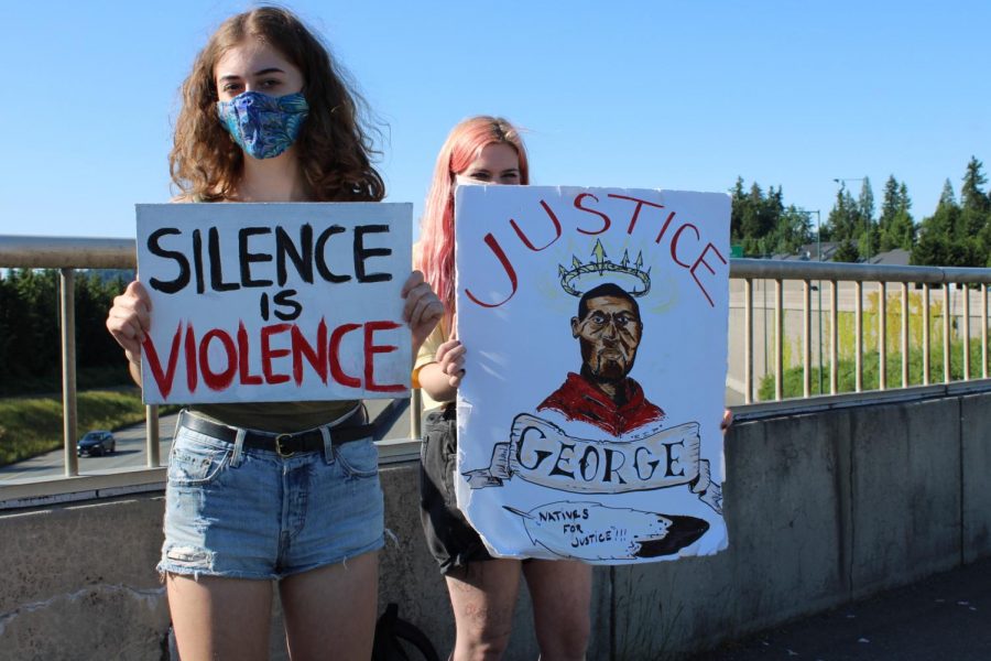 Northshore students Annika Anneberg and Katie Martin hold up signs in protest on the I-5, 160th Exit, on Monday, June 1st, following the death of George Floyd. They stood to bring awareness to as well as stand in alliance with the BLM movement. Photo by Rahima Baluch
