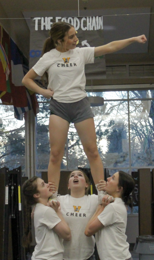 [From left to right] Junior Kaylee Ross (she/her), Senior Ciara Sutter (she/her) and Senior Erin Hill (she/her) hold up Sophomore Ava Gothenquist (she/her)
during a stunt. 