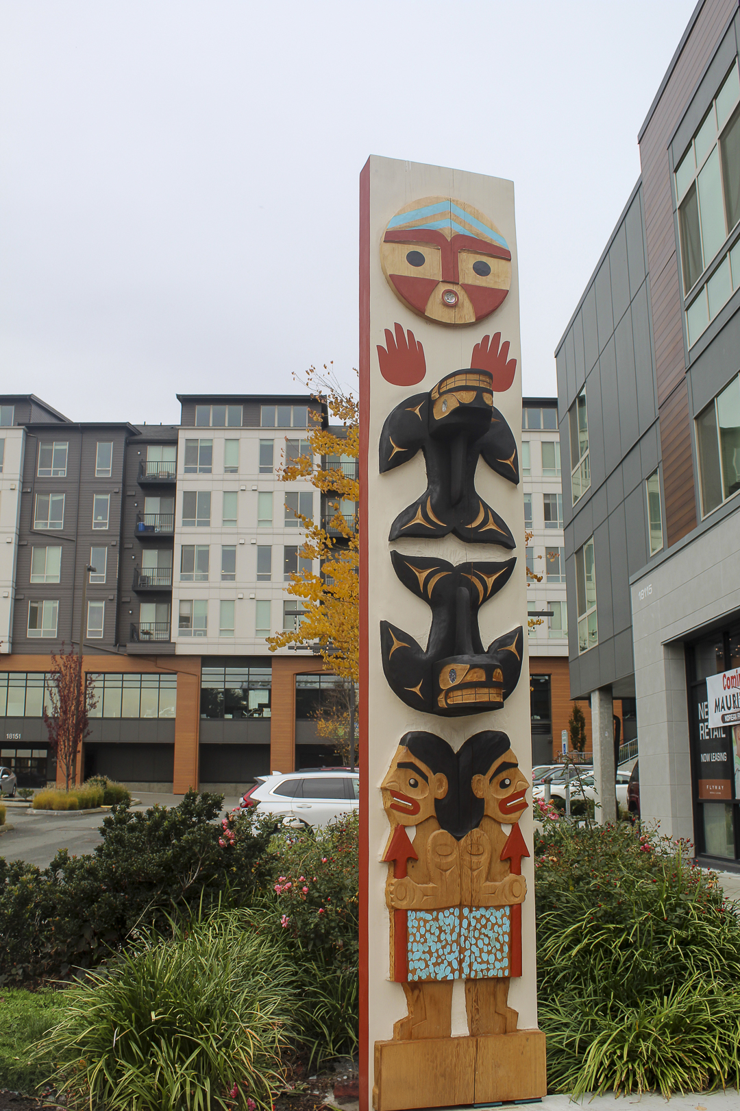A story pole outside the Kenmore Hangar, created by Tulalip artist Ty Juvinel.