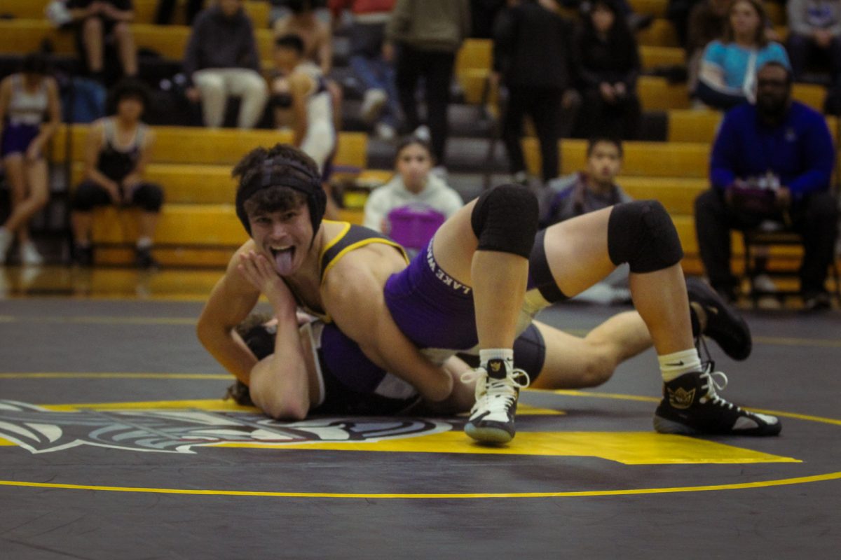 Jaden Perez poses for the camera as he pins his opponent in a half-nelson. 