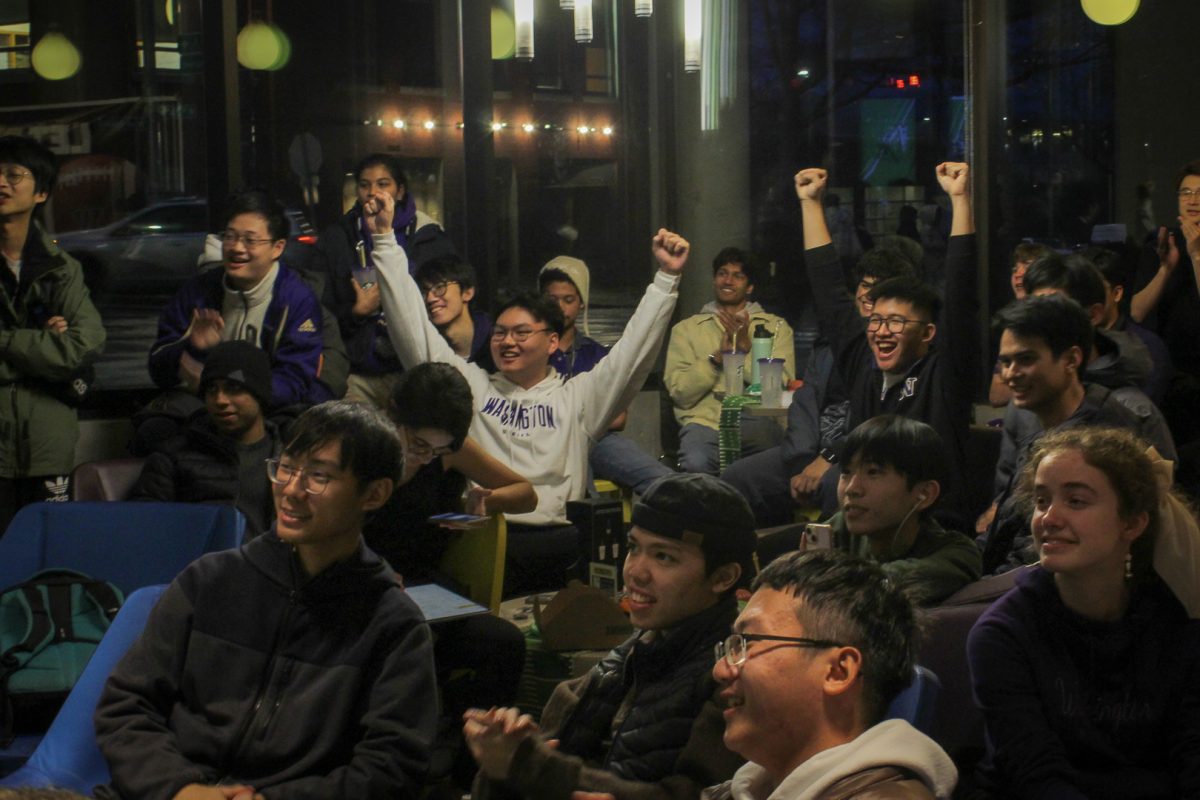 UW students celebrate a touchdown at a watch party for the national championship game. The watch party was held at Local Point, a restaurant on campus in Seattle.