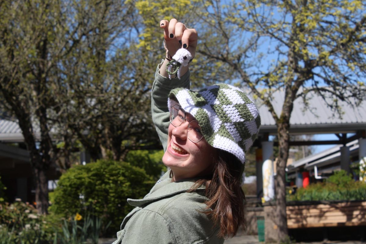 Jillian Rector holds up her stuffed jellyfish keychain. Rector also wore her checkered green and white crocheted bucket hat.