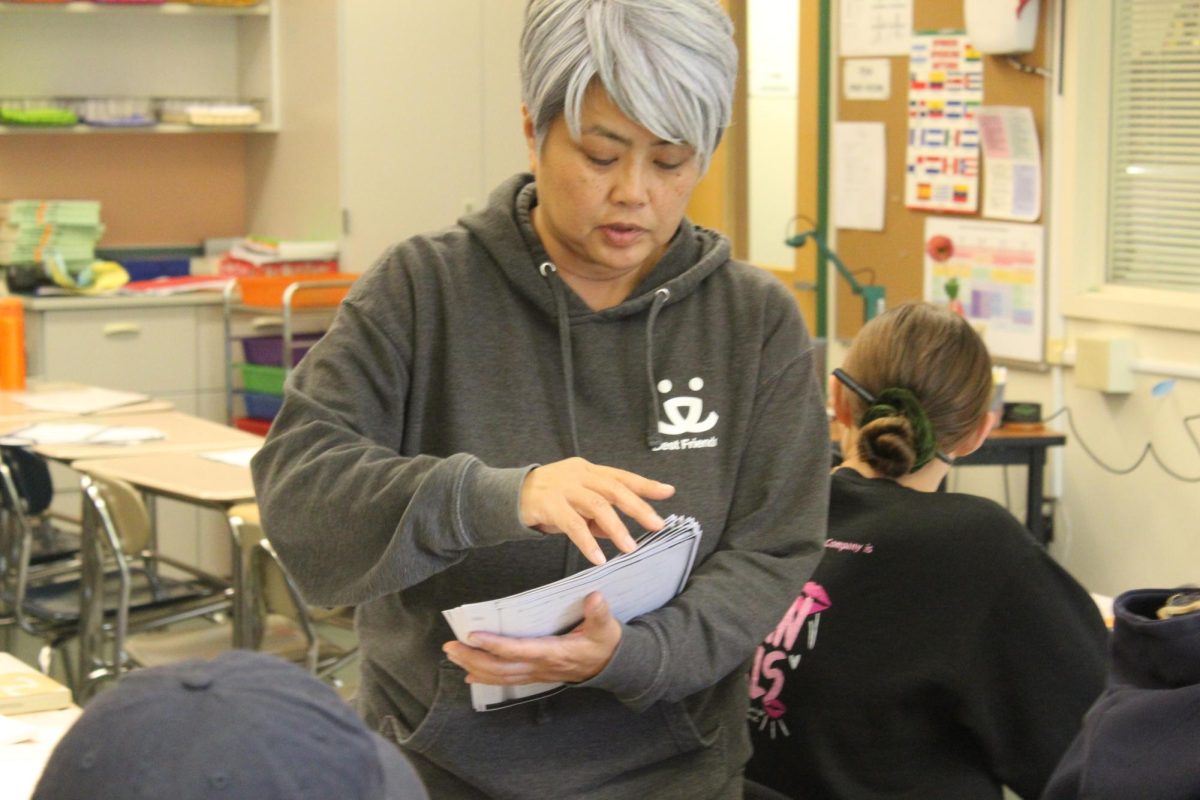 Kamitsuna distributes Kanji worksheets, Japanese characters, to her IB Japanese 300 class. 
