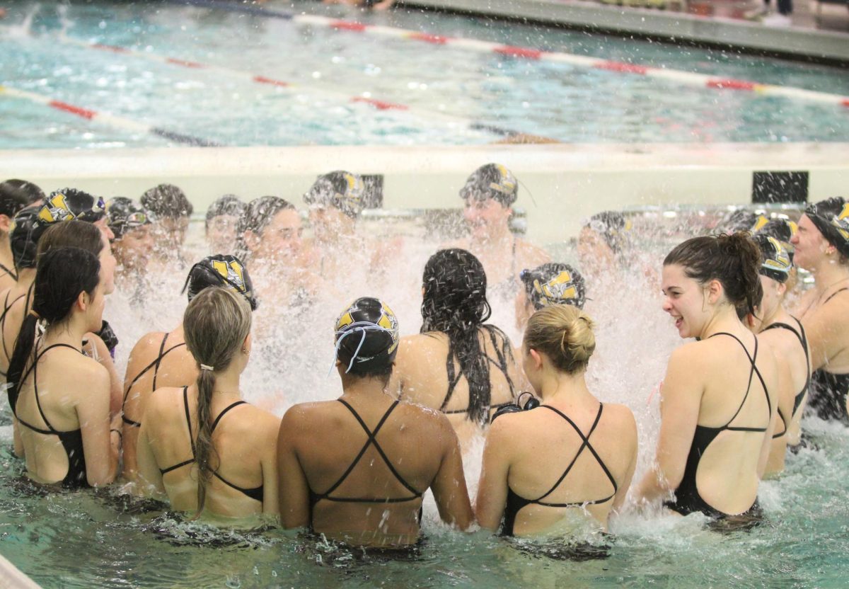 The girls swim and dive team splashes the water at the Juanita pool during their final cheer before their meet against North Creek on Sept. 25. They won their meet 119-64.