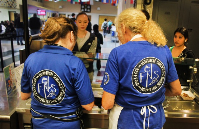 Full time cook Elaine Ackaret (left) and substitute cook Caroline Pittsford (right) prepare and serve trays of orange chicken and rice. “Mostly it’s filling empty spots as people are on leave, vacation, sick, but I think probably every school has an empty spot that needs to be filled,” Pittsford said. Photo by Crayson Mavrinac
