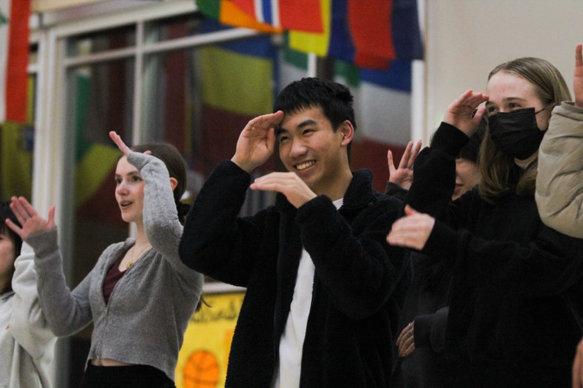 Chinese 300 and 400 students dance and sing to a Chinese song.