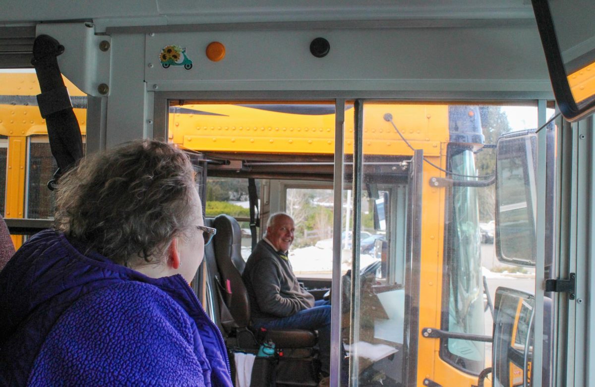 Davenport and Griffith laugh over stories through the window and door of their buses. “Being a bus driver gives me a chance to have a lot more friends, a lot more people to talk to, and I really enjoy that,” Griffith said. They often chat in the Inglemoor parking lot before students board.