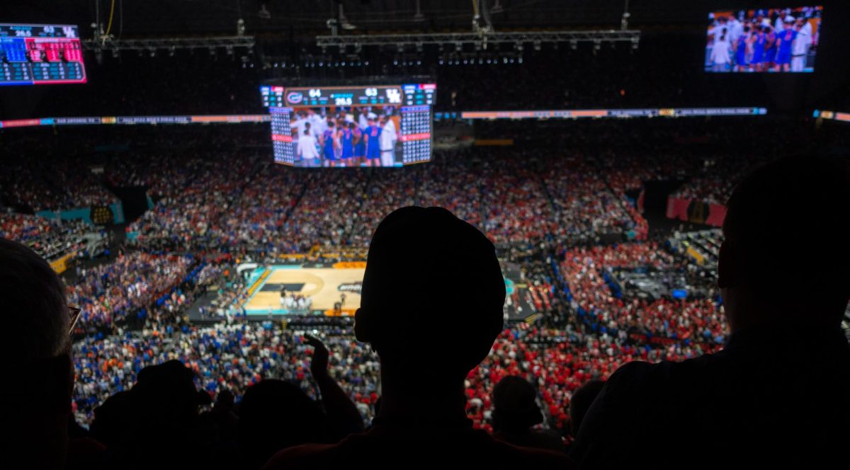Fans watch one of the final timeouts of the game on the jumbotron as Florida and Houston come up with last-second strategies to win the game.