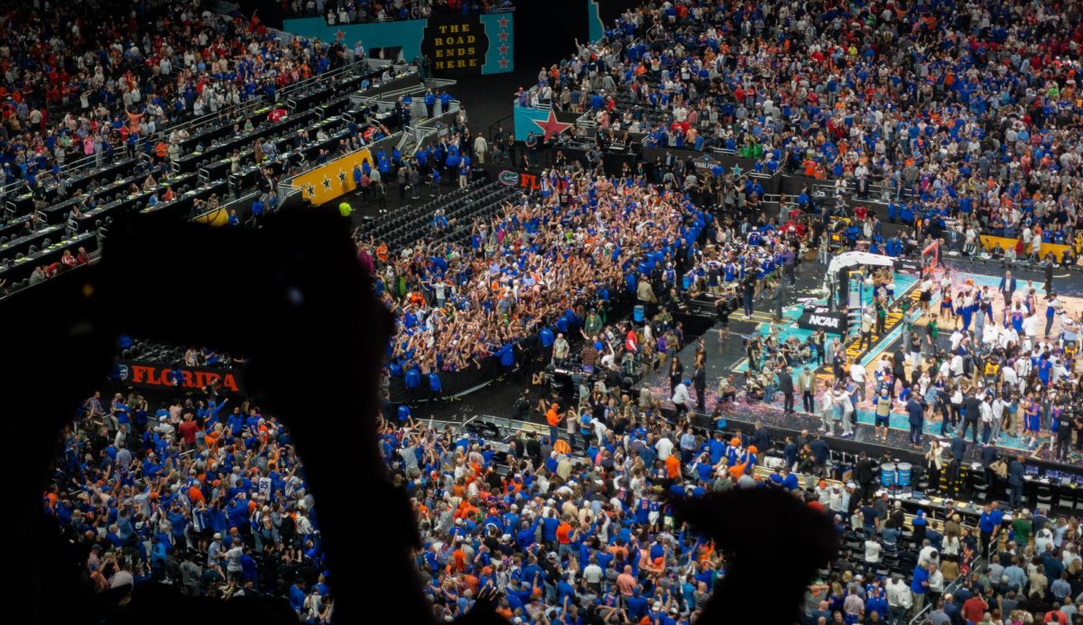 The Florida Gators student section celebrates after their team wins the National Championship title. A line of security guards moved in front of the section in order to keep the students from rushing the court.