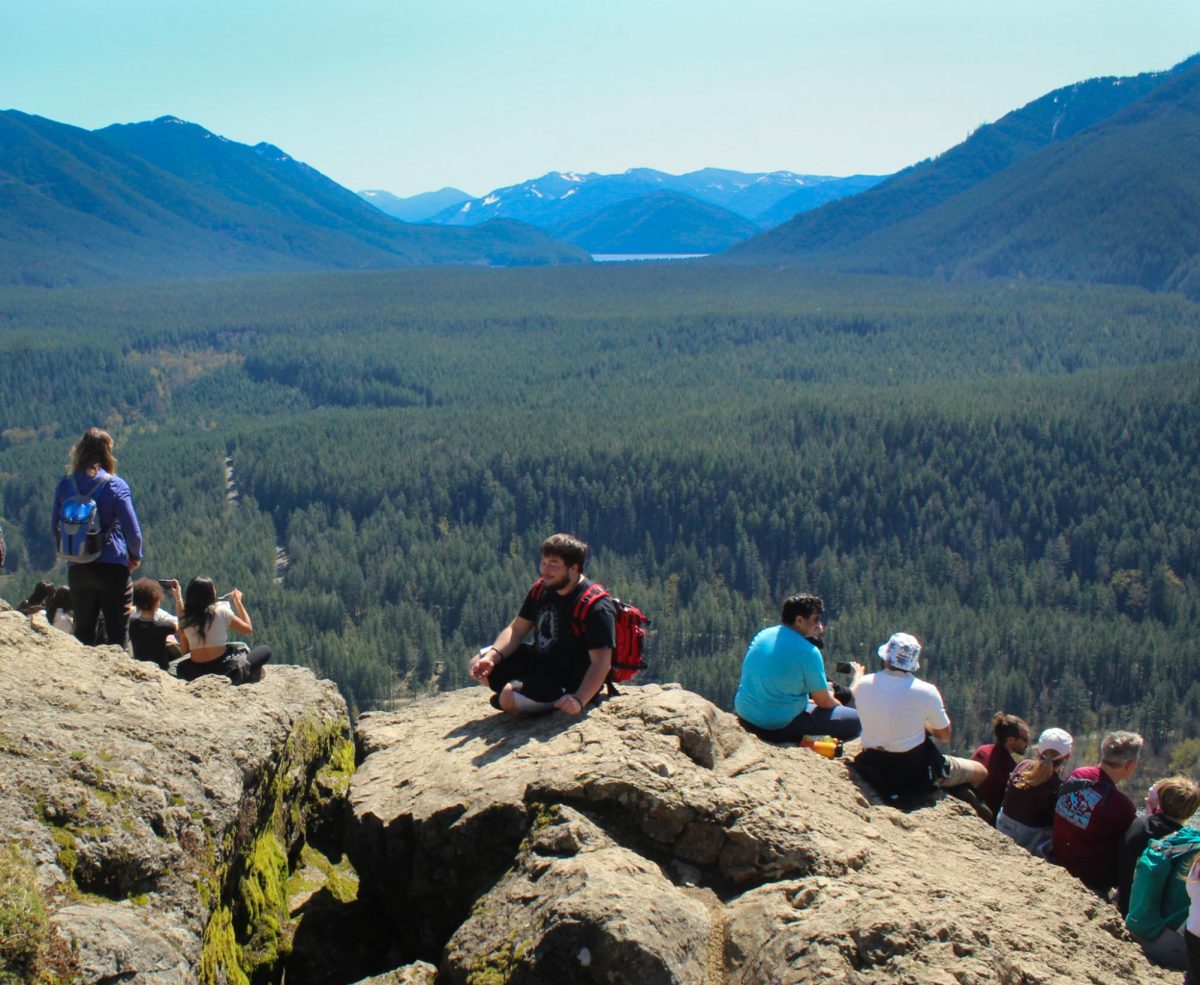 Hikers admire the Cascades from the Rattlesnake Ledge overlook.