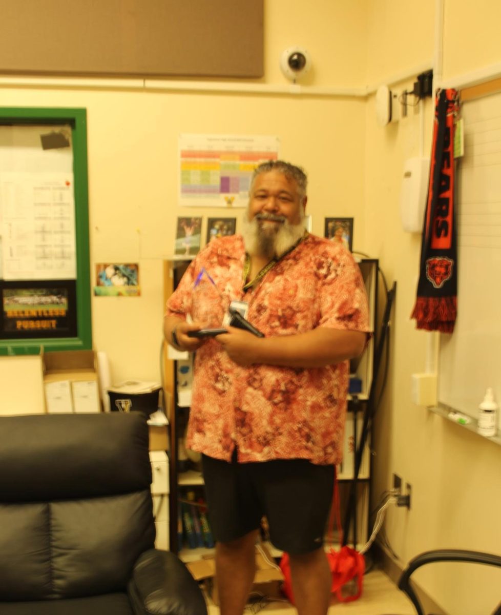 Calhoun stands with his Education Support Professional trophy in his office.
