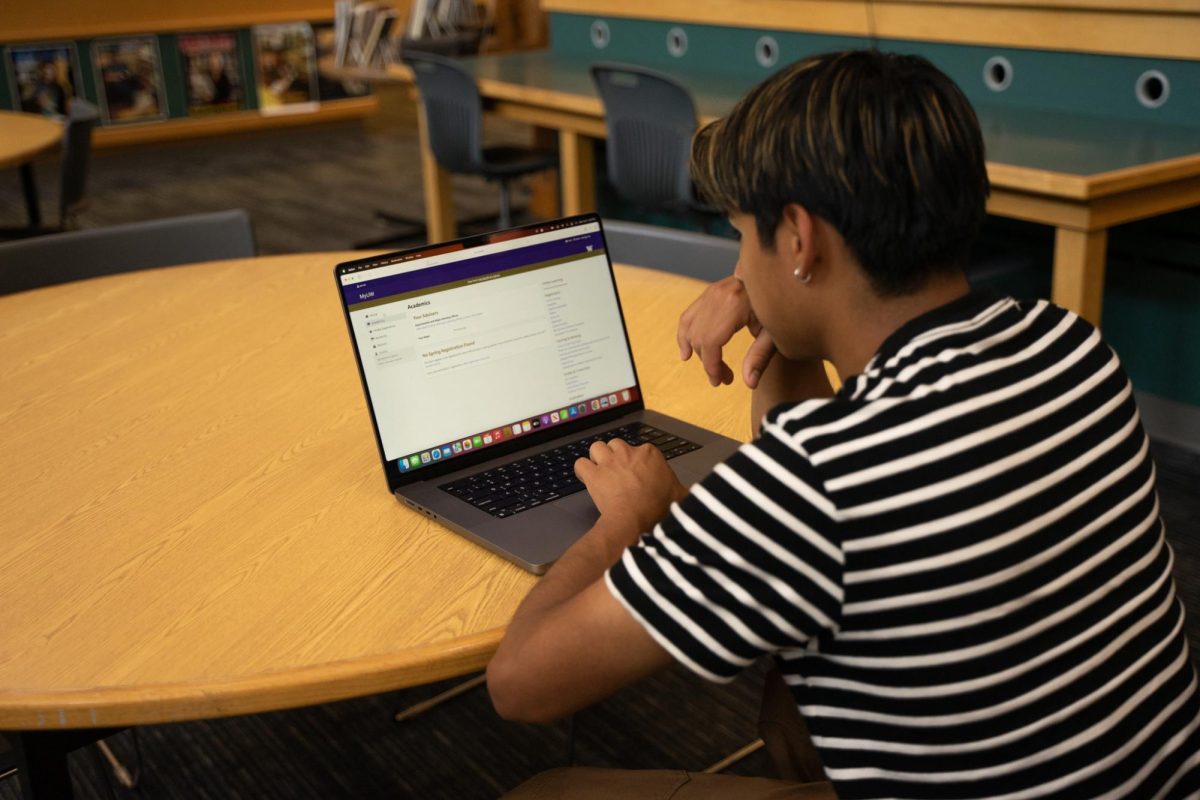 Senior Victor Bautista (he/him) examines the University of Washington student homepage for freshman updates. He plans to pursue a construction management degree in the fall.