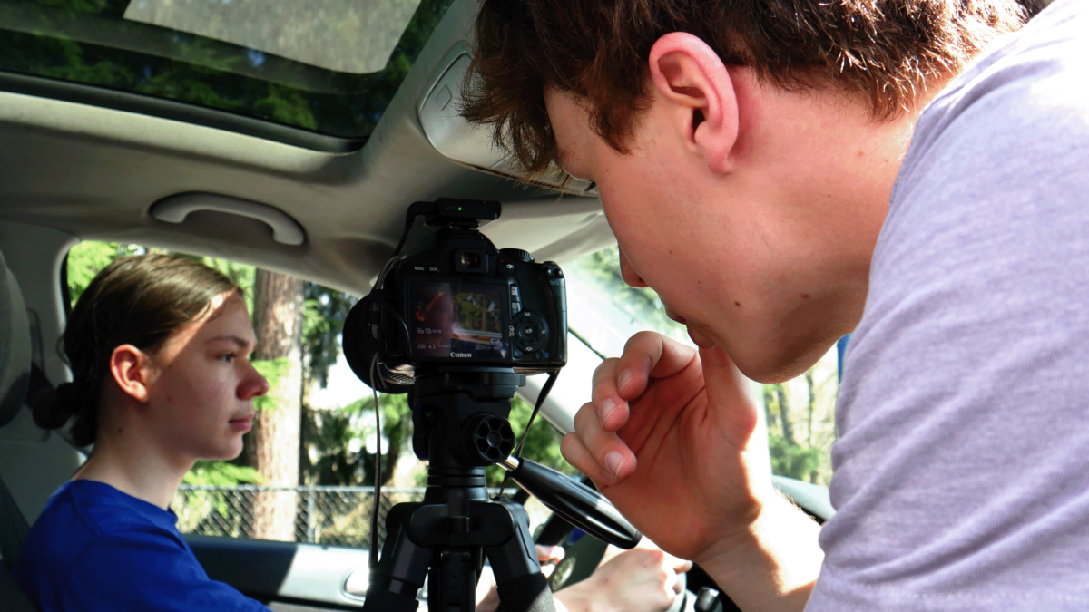 Fisher focuses his camera to take a shot in his distracted driving PSA.