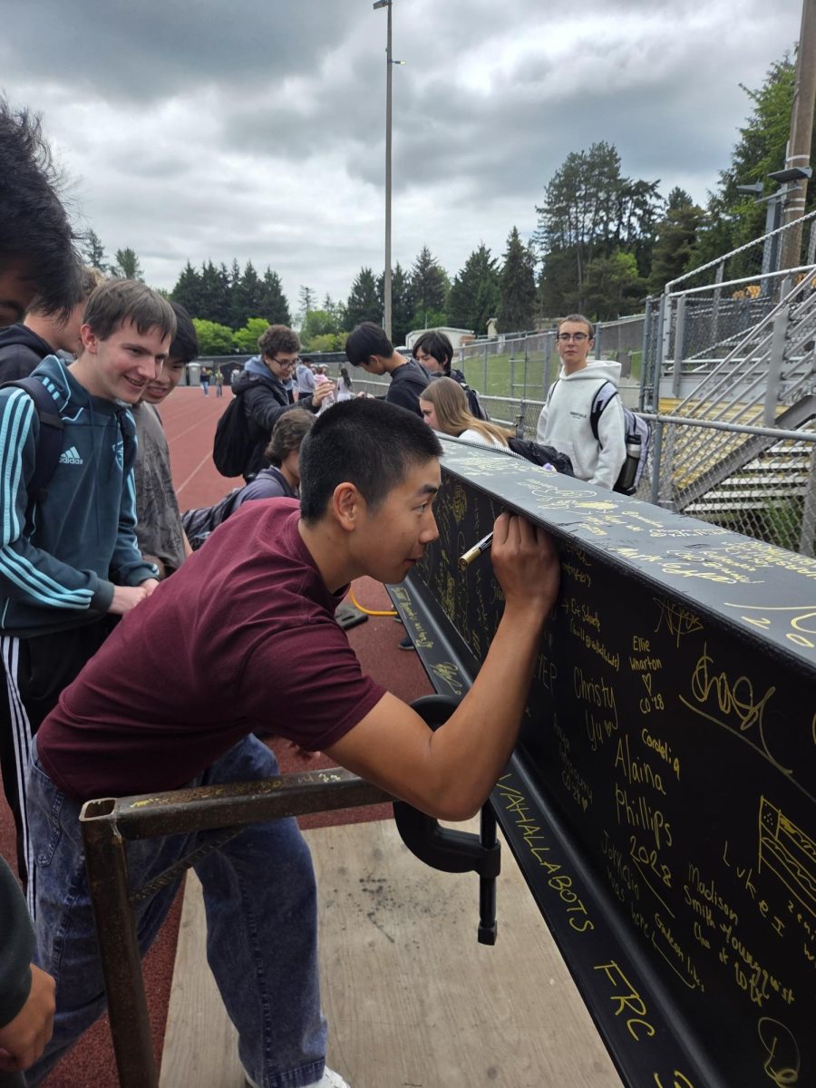 Making his mark on IHS’ future, junior Aaron Guo signs his name on the final beam placed as part of phase 1 construction. On May 7, students had the opportunity to sign the beam before it was put in place.